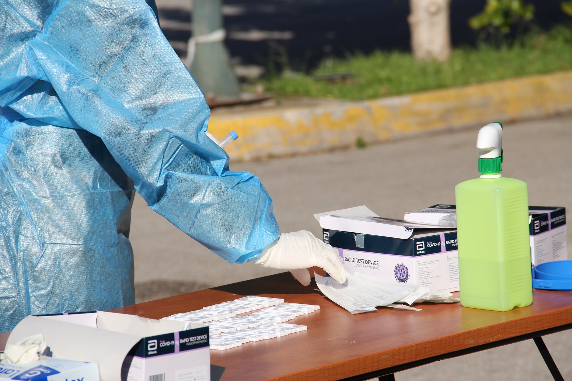 a person putting the rapid test device on the wooden table